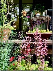 ピンクの花と緑あふれるベランダがある庭の写真